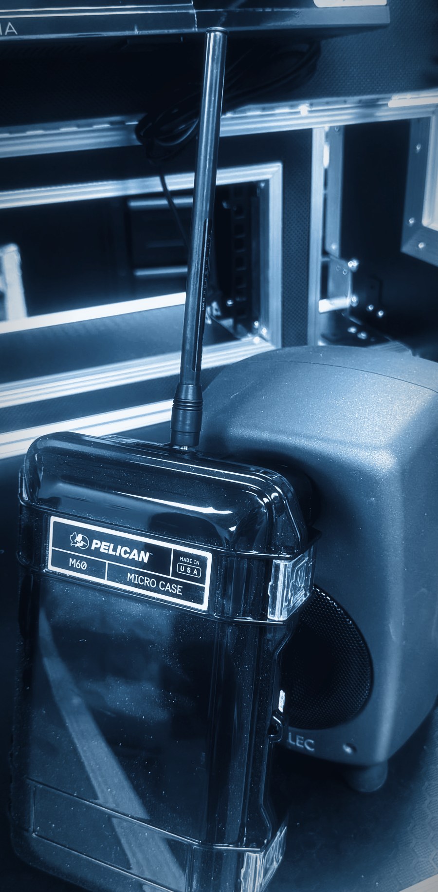 eighty32 FreqShow node — Pelican M60 case with SDR and whip antenna, leaning on a Genelec monitor